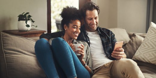 Man and Woman on Couch looking at mobile phone